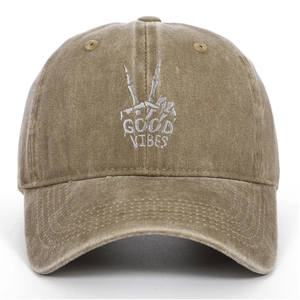 Close-up of skeleton hand embroidery and GOOD VIBES text on washed cotton baseball cap