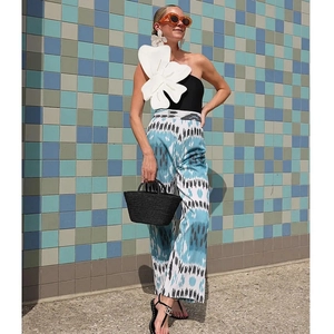 One-shoulder black swimsuit with 3D white flower detail and pattern wide-leg pants