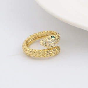 Dettaglio macro dell'anello a serpente dorato con occhi verdi e zirconi brillanti