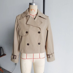 Detail of double-breasted khaki short trench jacket with wide lapels and epaulettes