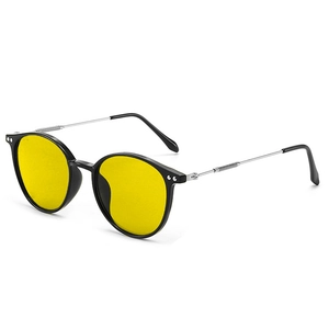 Detail of round sunglasses with vibrant yellow lenses and black-silver metal frame
