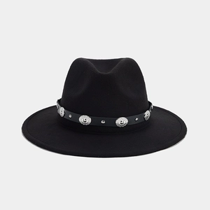 Détail du chapeau fédora noir avec bandeau en cuir orné de clous et de motifs argentés