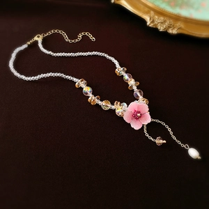 Elegant beaded necklace with pink flower pendant, gold tassel and a white pearl drop