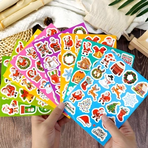 Festive Christmas sticker set featuring colorful Santa Claus and reindeer on a wooden desk