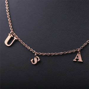 Vue détaillée des pendentifs USA en acier inoxydable or rose sur chaîne fine