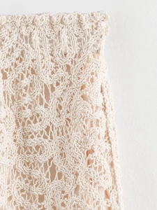 Détail du tissu en dentelle crochetée beige avec motifs floraux et doublure intérieure douce