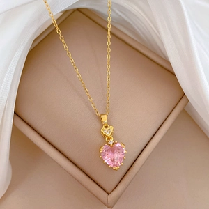 Close-up of a pink heart-shaped crystal necklace in a beige jewelry gift box