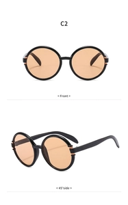 Detailansicht der übergroßen runden Sonnenbrille mit schwarzem Rahmen und bernsteinfarbenen Gläsern