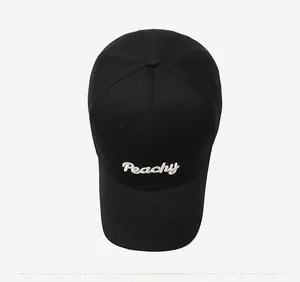 Top view of a black cotton baseball cap featuring detailed white Peachy embroidery