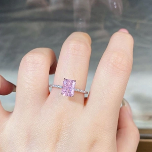 Macro shot of 2 carat pink radiant cut zircon silver ring with pavé diamond band