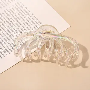 Macro shot of large iridescent acrylic hair claw clip with colorful laser finish effect