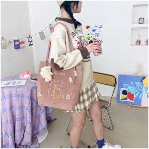 Detail of pink corduroy tote bag featuring bear embroidery and cute decorative badges