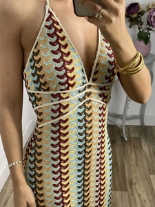 Close-up of bohemian crochet halter dress featuring vibrant scale-like knit patterns
