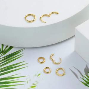 Macro shot of polished gold hoop earrings showing closed and semi-open structures