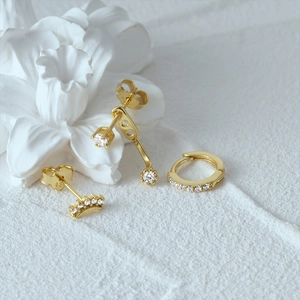 Close-up of gold 925 sterling silver earrings set with sparkling clear stones