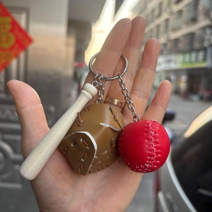 Close-up of baseball keychain with brown glove, red leather ball and small wooden bat