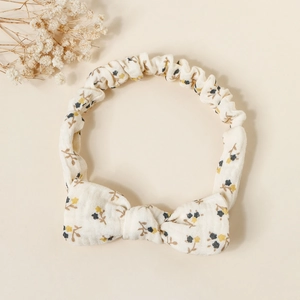 Detail of floral cotton baby headband with bow and elastic band in rustic style
