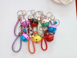 Colorful bell keychains with hand-woven ropes in vibrant candy colors displayed on a surface