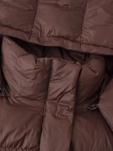 Détail d'une veste matelassée marron avec capuche, col montant et finitions de couture