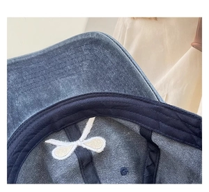Makroaufnahme einer gewaschenen Jeans-Basecap mit innerem Schweißband und Stickerei