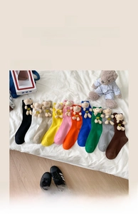 Detail view of colorful cotton socks set featuring adorable 3D plush teddy bear ornaments
