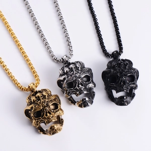 Close-up of three skull pendant necklaces in gold, silver and black finishes
