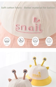 Detail of pink and yellow baby snail bucket hats with snail embroidery and 3D antennas