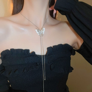 Detail of silver butterfly tassel necklace on model highlighting the Y-shape design