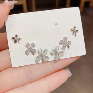 Detailed set of three clover stud earrings featuring opal-like resin and crystal pavé