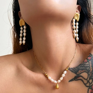 Gold stainless steel shell earrings and pearl necklace set worn by a model in summer style