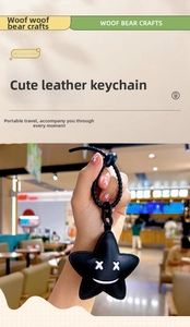 Detail of star-shaped black leather keychain with stitch smile and bead chain strap