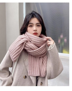 Close-up of thick pink knit scarf showing textured chunky weave and cozy style