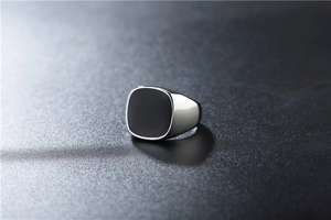 Macro detail of men's square black enamel signet ring in polished stainless steel finish