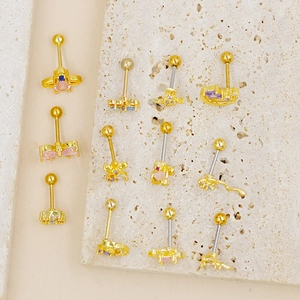 Detailed close-up of golden piercing studs with colorful zircon on a textured stone base
