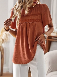 Detail of red-brown boho blouse featuring textured Swiss dots and lace crochet stitching