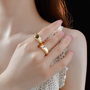 Nahaufnahme von Vintage-Goldringen mit Tigerauge und Zirkonia am Finger des Models