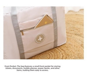 Detailed view of pink nylon travel bag front zipper pocket holding a gold smartphone