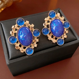 Vintage gold hollow rhombus earrings with oval blue resin stones in luxury style
