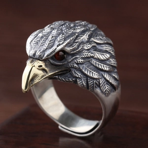Detailed close-up of vintage eagle ring with golden beak and red gemstone eyes
