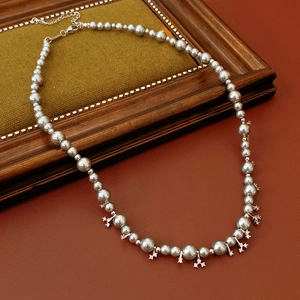 Detailed macro view of gray pearls and diamond pendant on a vintage wooden frame