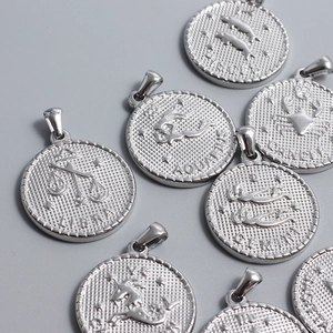 Polished stainless steel zodiac coin pendants with embossed mesh texture and gear edge