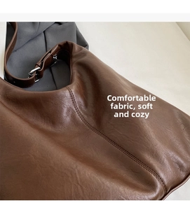 Close-up of brown faux leather hobo bag showing soft texture and silver buckle detail