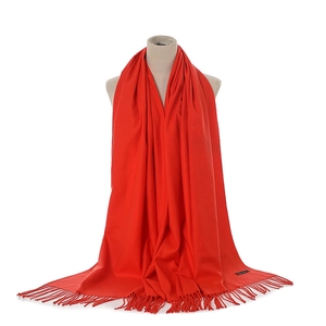 Detail of red cashmere-feel scarf with elegant fringes displayed on a mannequin