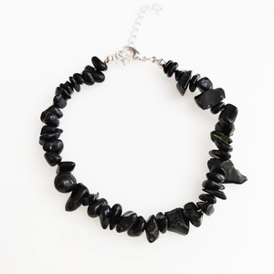 Close-up of irregular black obsidian stone bracelet with silver lobster clasp and chain