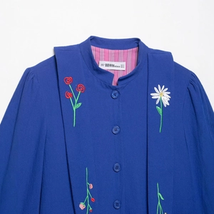 Royal blue long sleeve shirt with floral embroidery and stand collar on white background