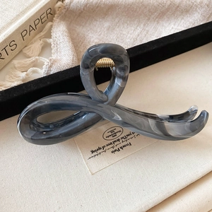 Detail of a large grey marble texture hair claw clip made of acetic acid plate