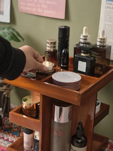 Macro detail of a brown wooden 360 rotating makeup organizer showing multi-tier storage