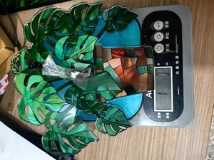 Detail view of acrylic monstera leaf suncatcher with vivid green patterns and hanging kit