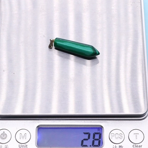 Vue détaillée d'un pendentif en malachite verte sur une balance indiquant un poids de 2,8g