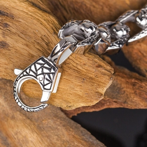 Macro shot of industrial titanium steel chain with engraved lobster clasp on wood